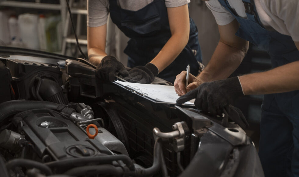 male-female-mechanics-working-shop-car
